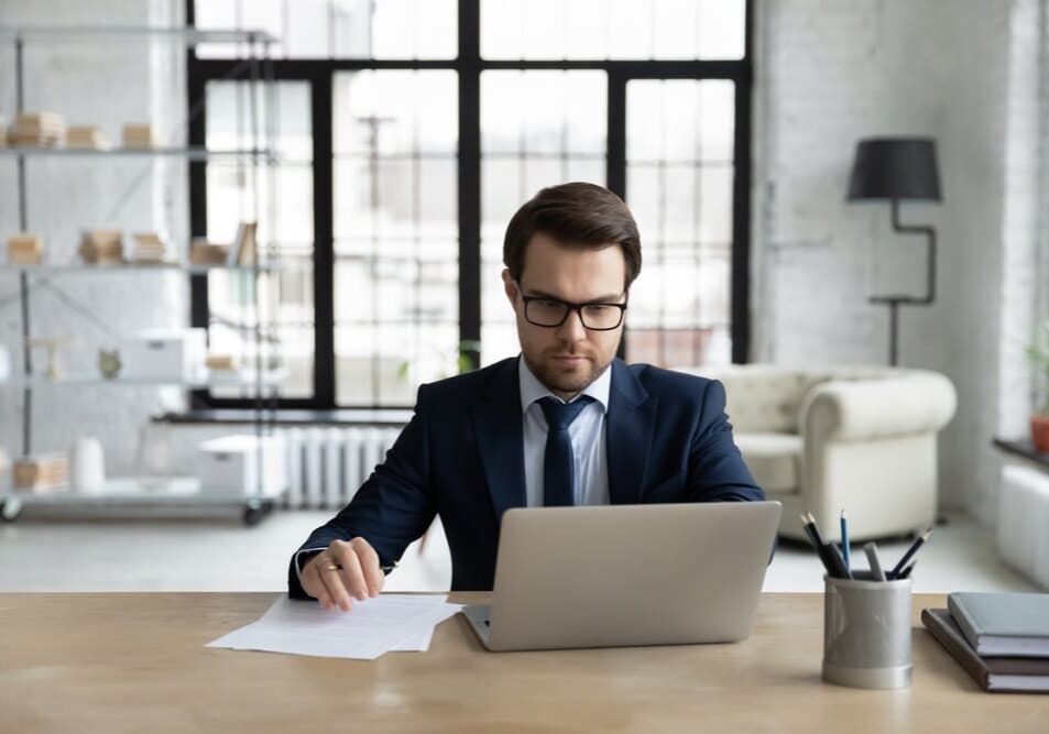 Serious,Young,Caucasian,Male,Boss,Or,Ceo,Sit,At,Desk reviewing candidates for the job position